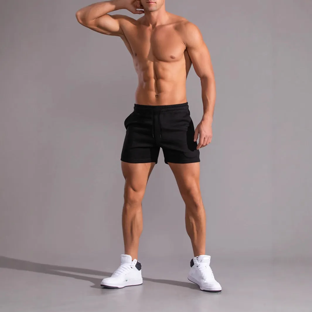 Three pairs of men's solid-colour drawstring shorts in black, khaki, and light brown laid flat.