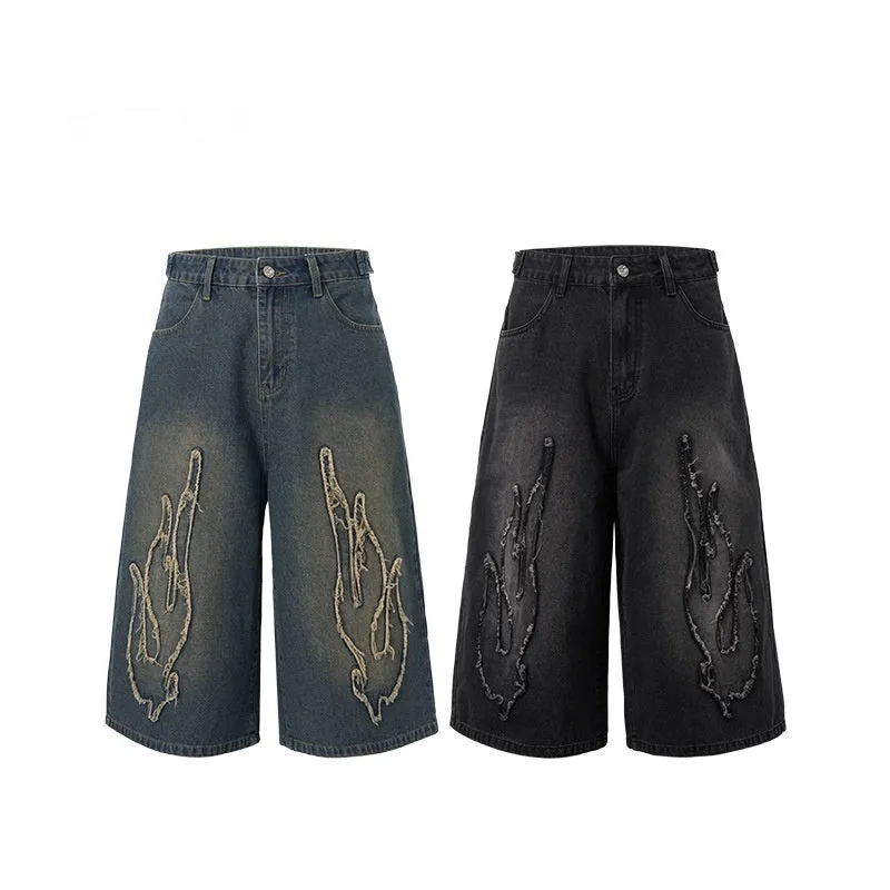 Men's black cropped denim shorts with orange flame embroidery patch on leg