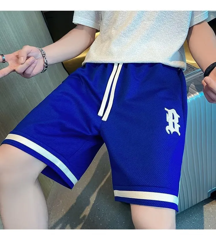 Men's loose straight drawstring sports shorts in solid colour with wide leg and low waist on plain background