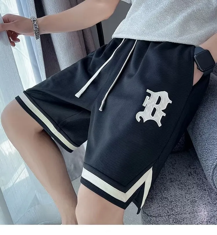 Men's loose straight drawstring sports shorts in solid colour with wide leg and low waist on plain background