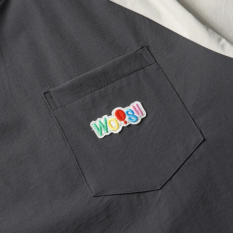 Dark grey loose fit t-shirt with light coloured raglan sleeves on a hanger
