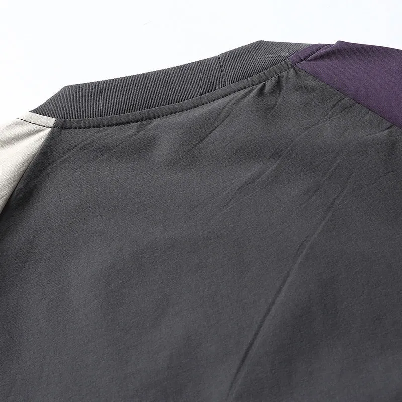 Dark grey loose fit t-shirt with light coloured raglan sleeves on a hanger
