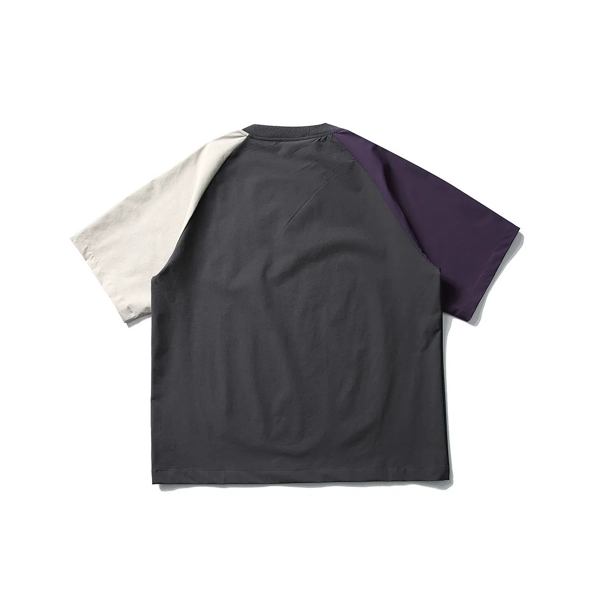 Dark grey loose fit t-shirt with light coloured raglan sleeves on a hanger