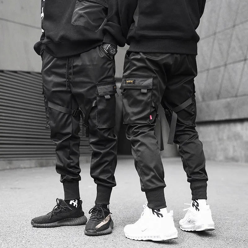 Black cotton cargo pants with tether closure, loose fit, ankle length, on a model