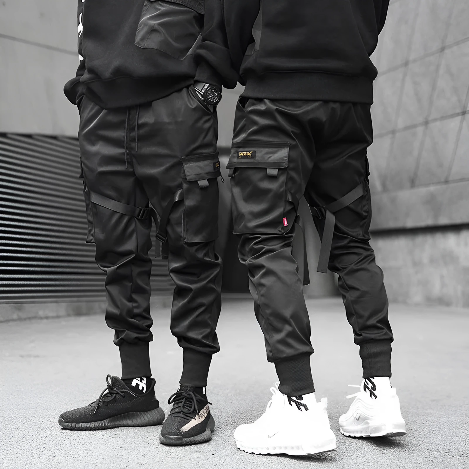 Black cotton cargo pants with tether closure, loose fit, ankle length, on a model