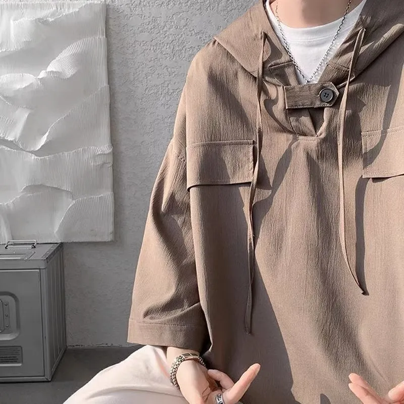 Man wearing a loose fit black hooded short sleeve T-shirt for summer.