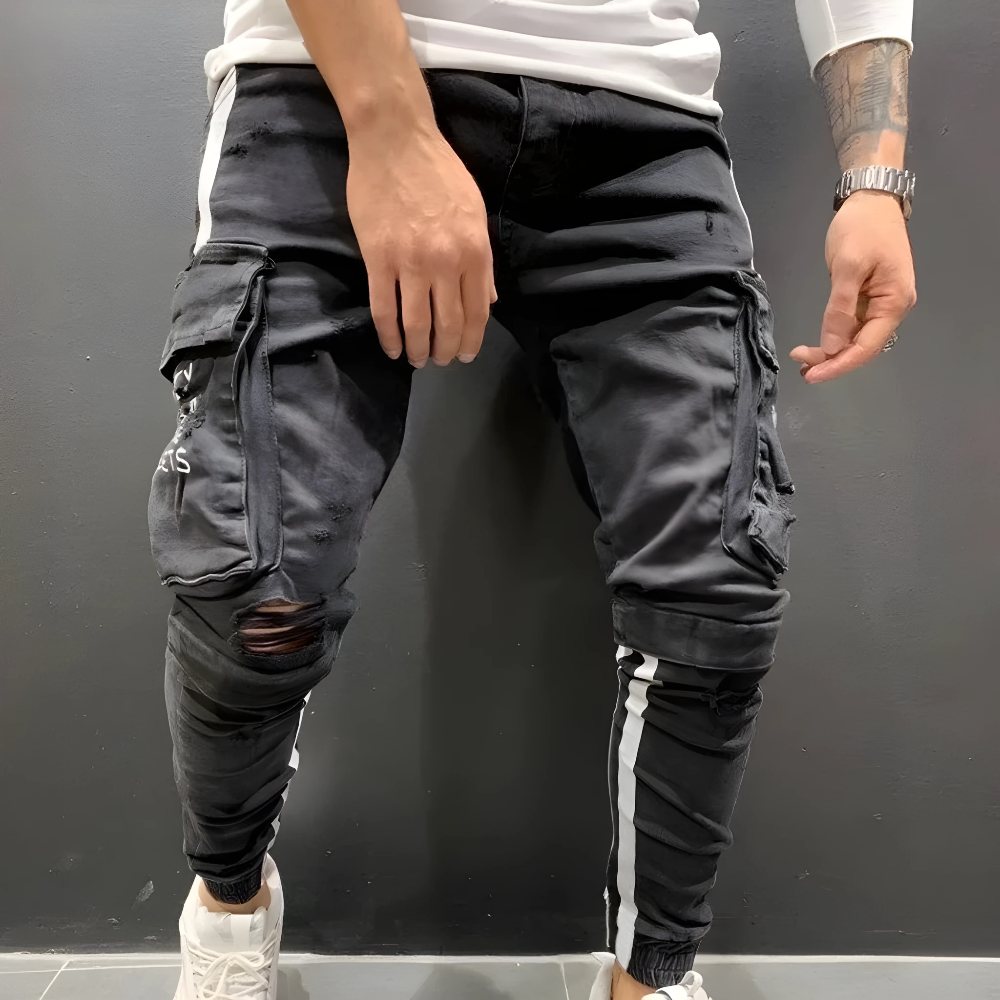 Men's denim knee-cut zipper trousers in black, 80% cotton, side view showing zipper placket and knee cut detail