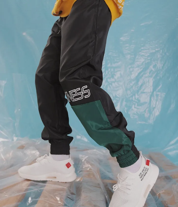 Green Japanese hip hop sweatpants with hit colour stitching, letter print, and bouquet floral design on a low-waist drawstring style