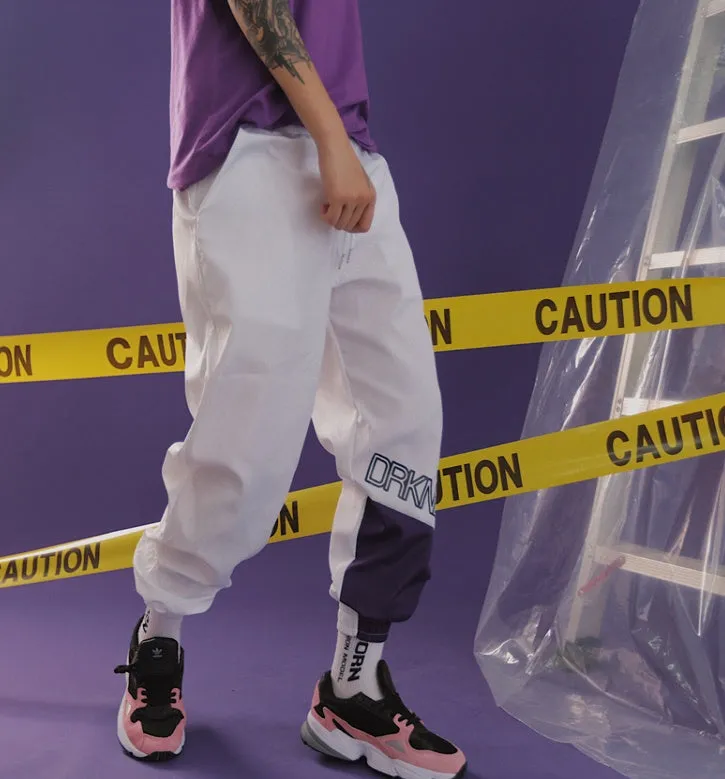 Green Japanese hip hop sweatpants with hit colour stitching, letter print, and bouquet floral design on a low-waist drawstring style