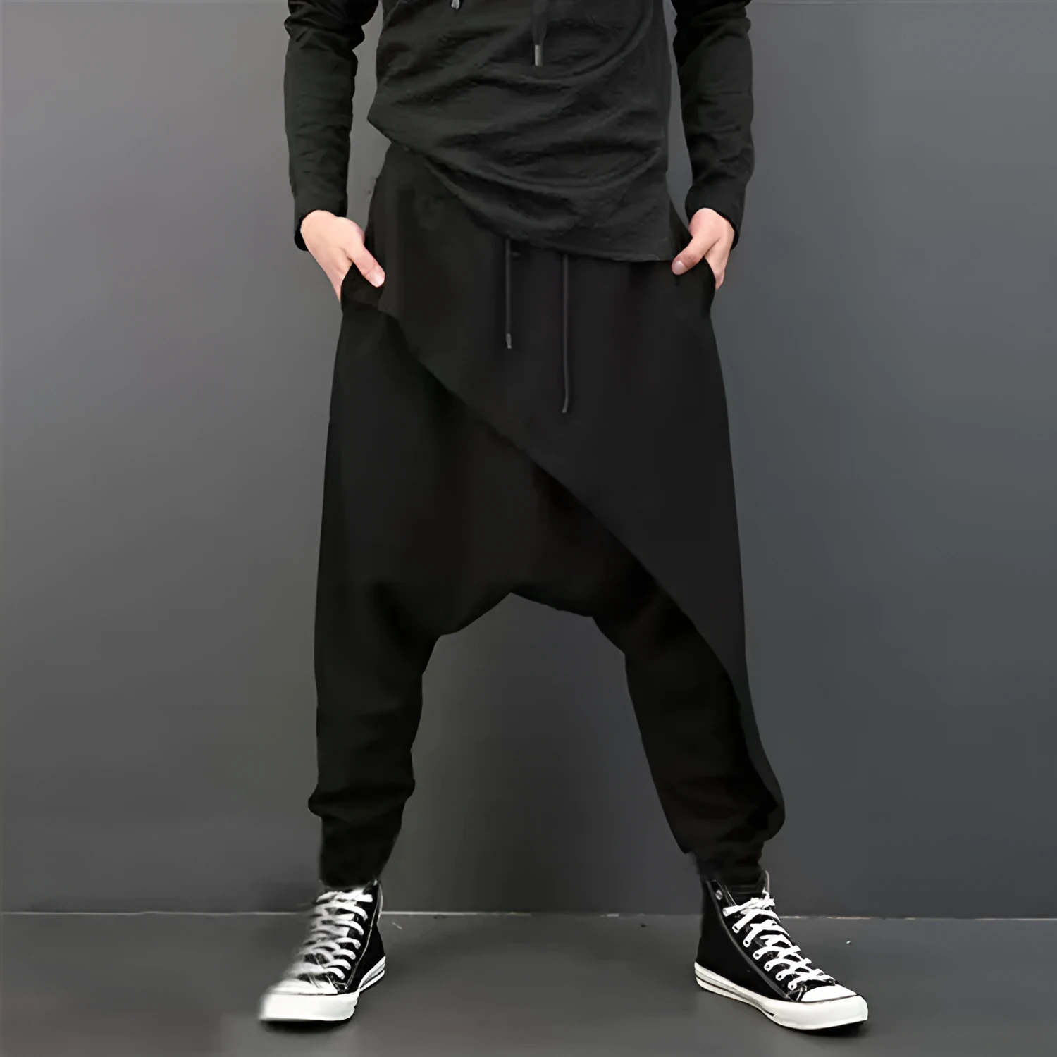 Cotton loose harem pants in black with elastic waist, side view on model