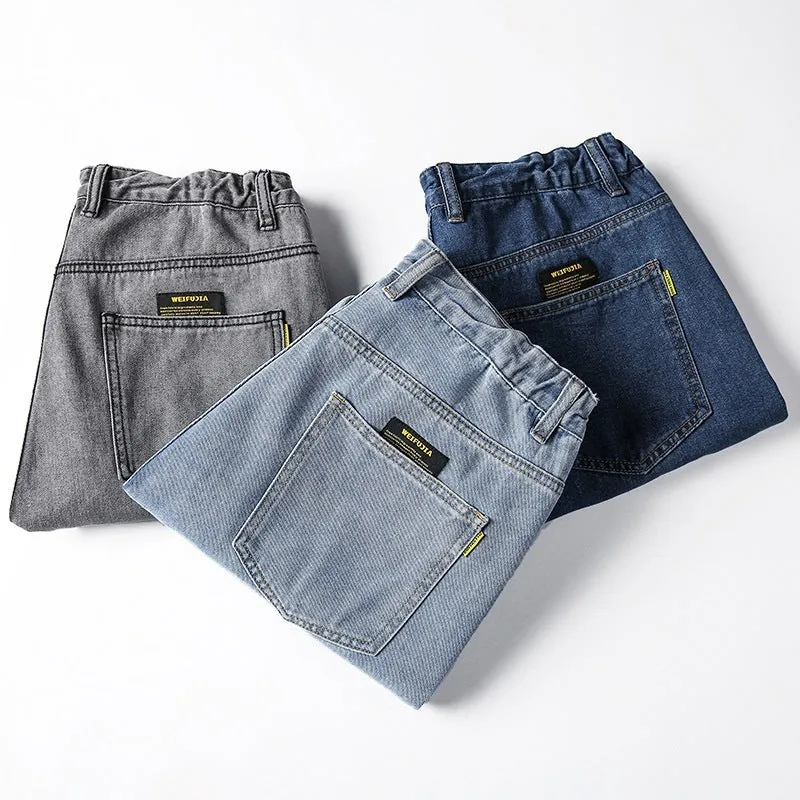 Men's dark blue loose straight-leg casual jeans on a hanger, showing mid-waist and zipper fly.