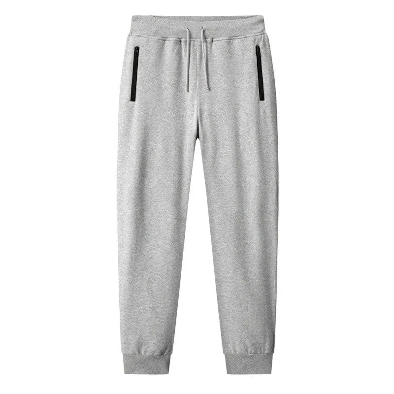 Men's thin leisure tapered knitted pants in black with ankle tie, standing on a neutral background
