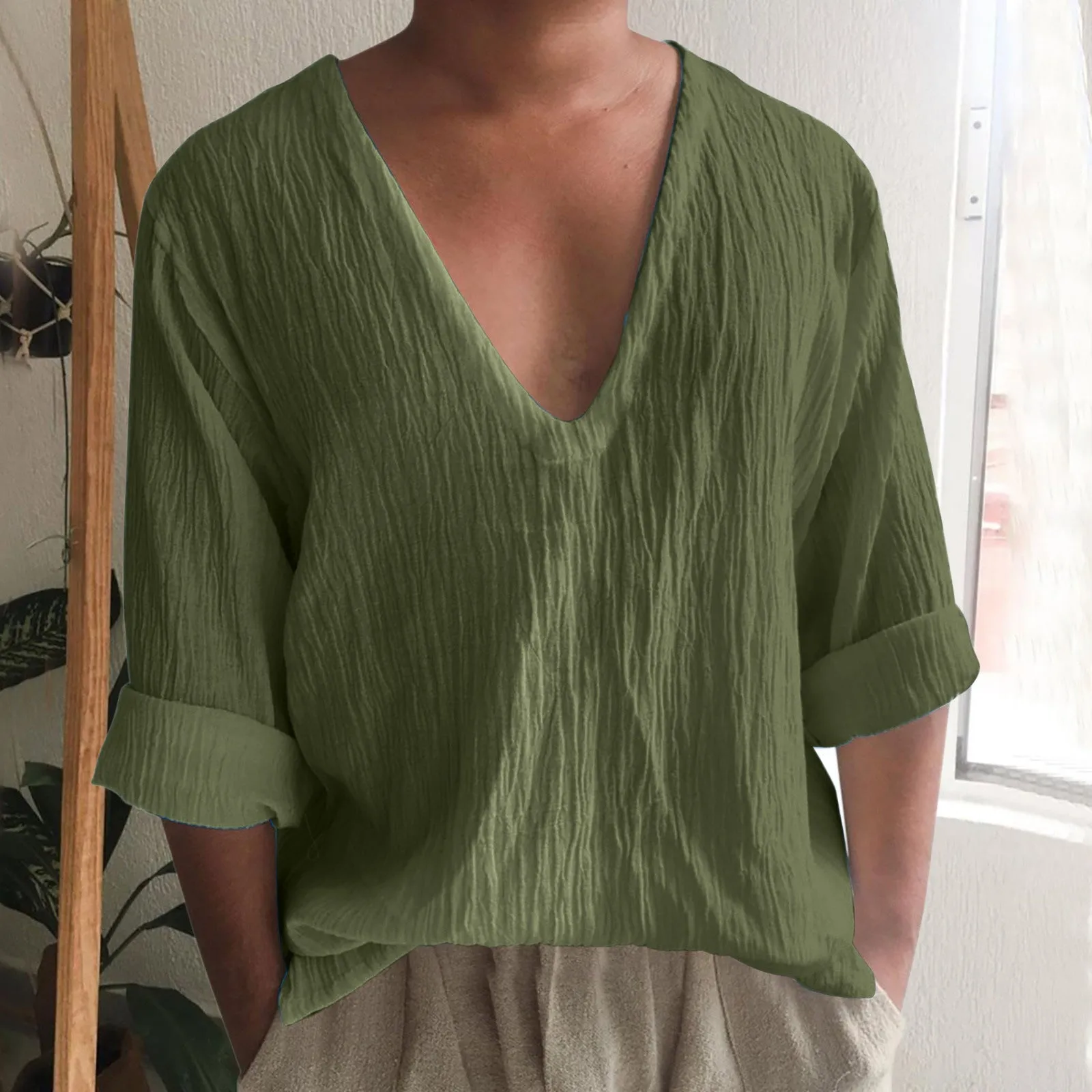 Man wearing a washed cotton long sleeve V-neck t-shirt in a solid colour.