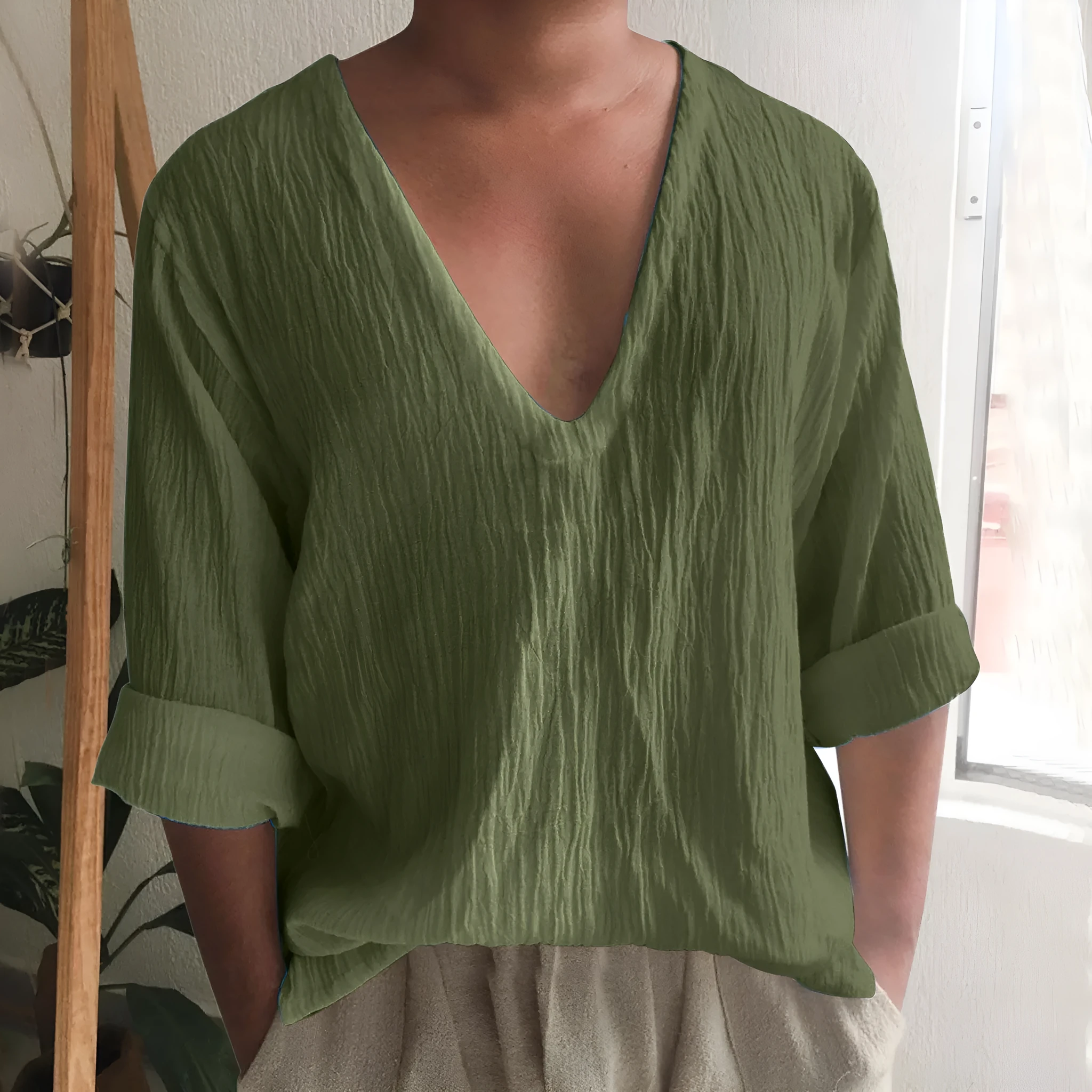 Man wearing a washed cotton long sleeve V-neck t-shirt in a solid colour.