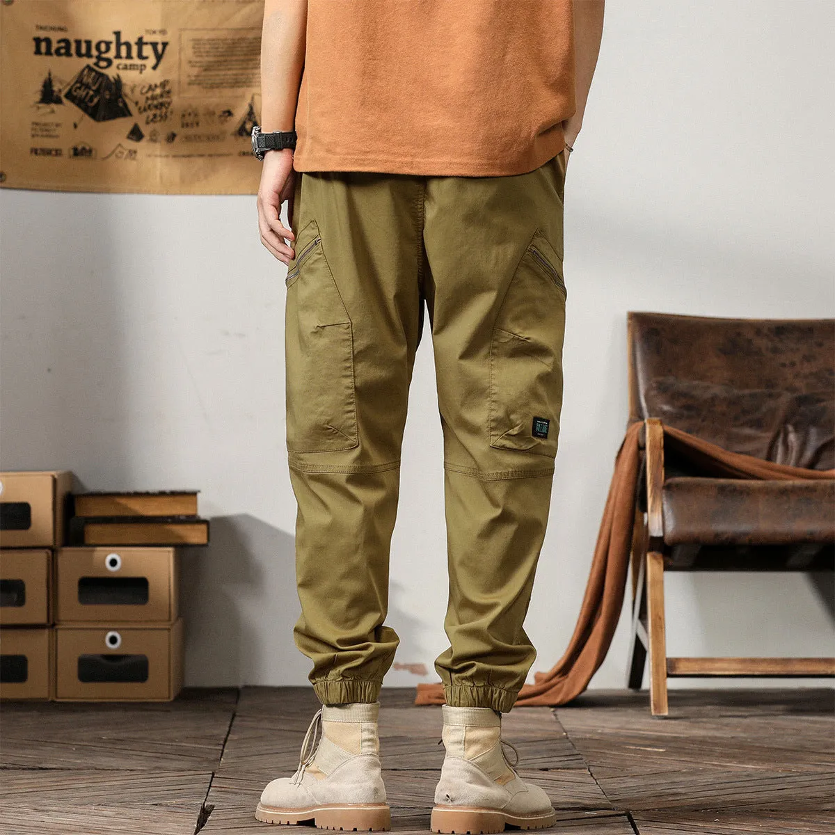 Men's khaki cotton harem pants with tapered leg and ankle band on a mannequin.