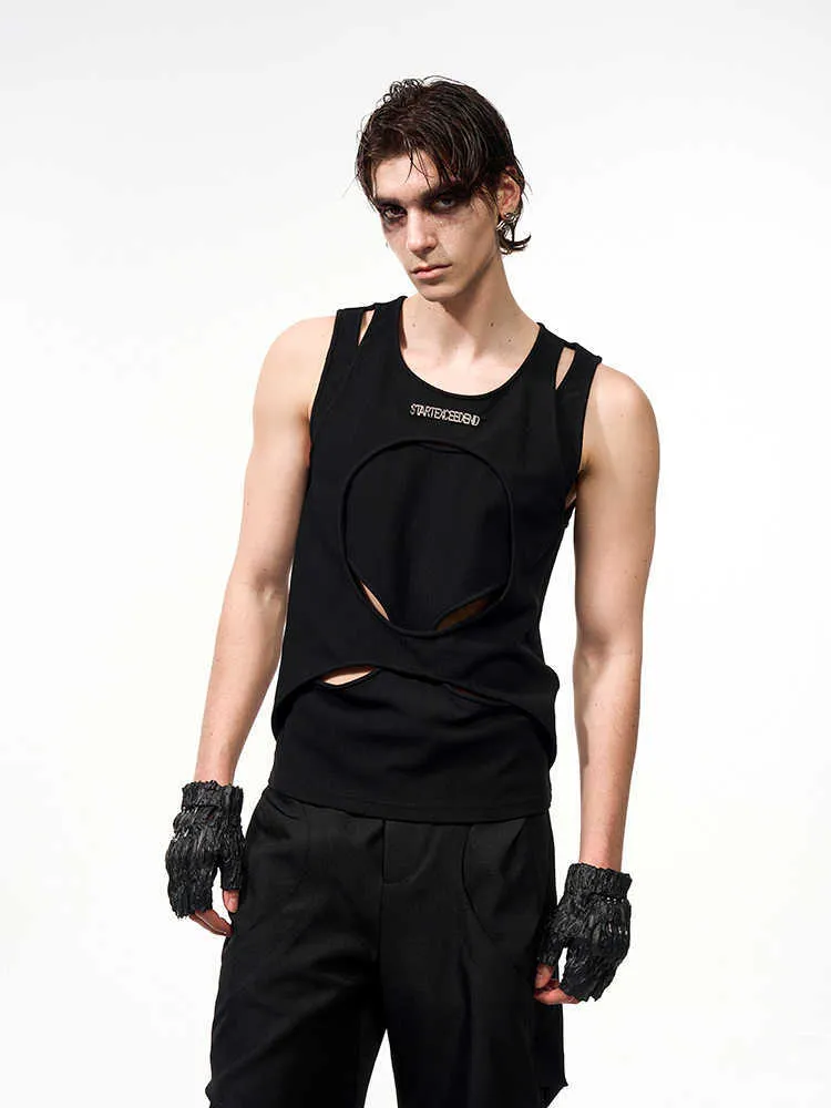 Man wearing a loose-fitting black sleeveless waistcoat with a round neck, made from a lightweight hollow thread fabric.