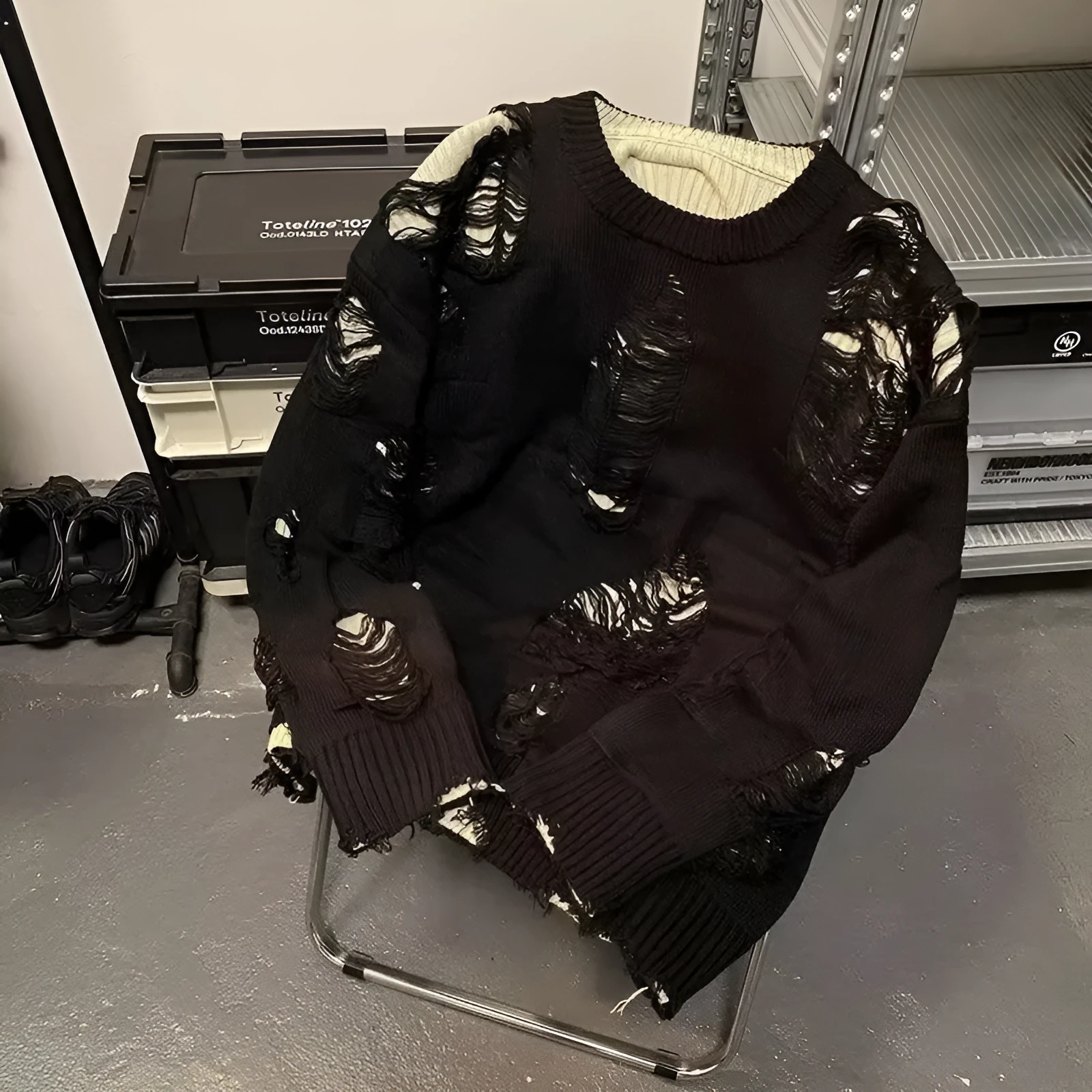 Men's black ripped pullover sweater with animal pattern and tassels on gray background