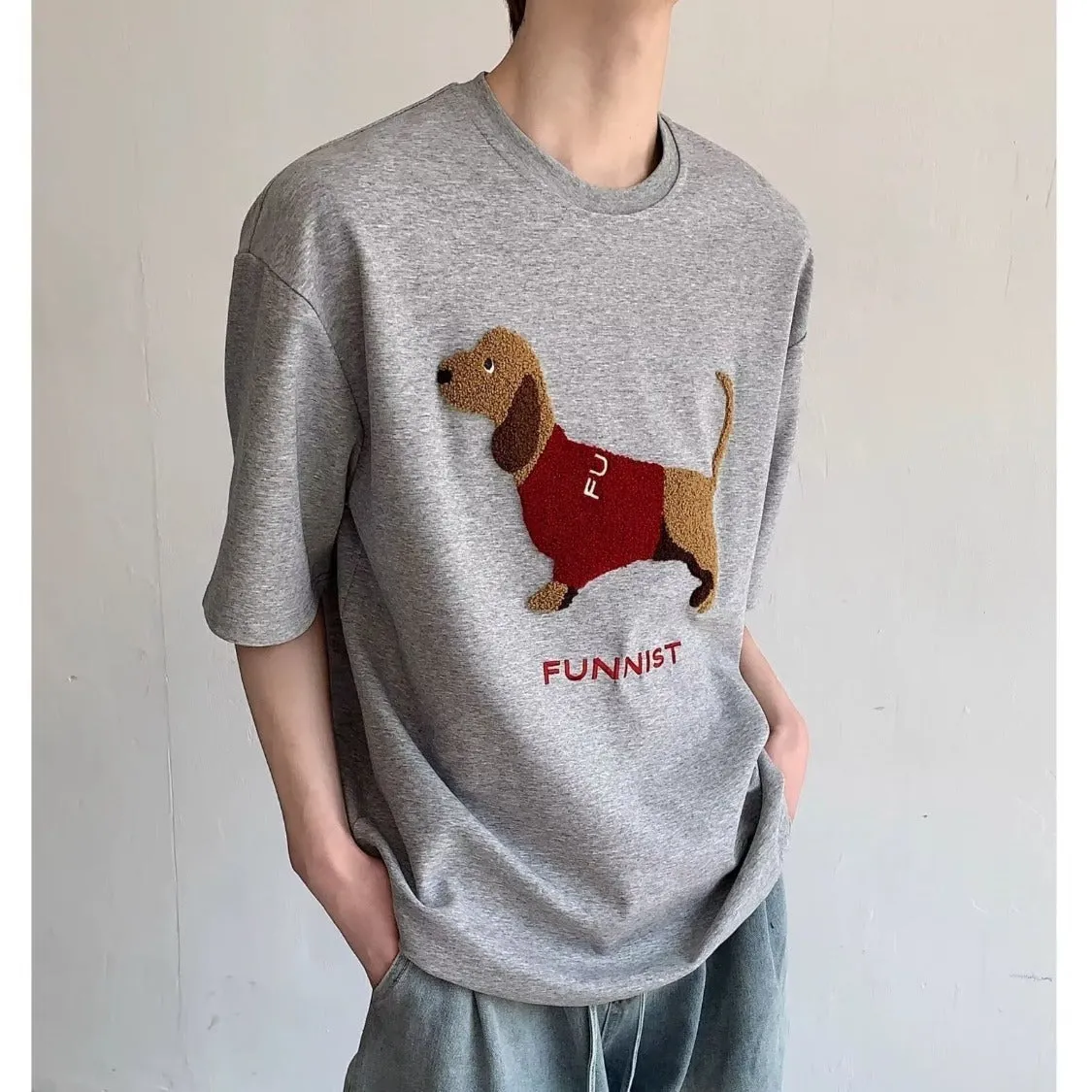 Men's gray cotton t-shirt with an embroidered cartoon sausage dog holding a blue towel.