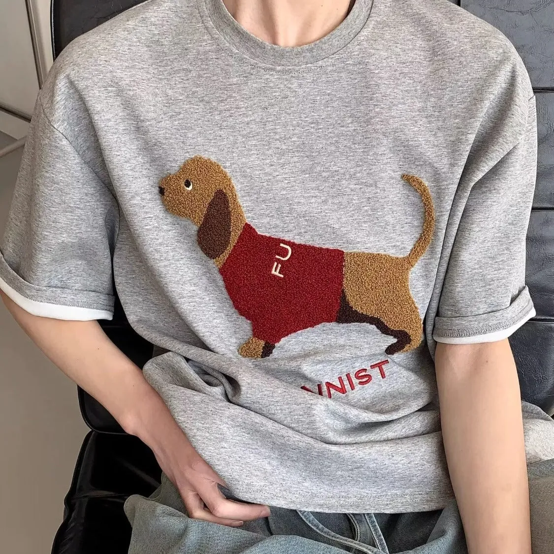 Men's gray cotton t-shirt with an embroidered cartoon sausage dog holding a blue towel.
