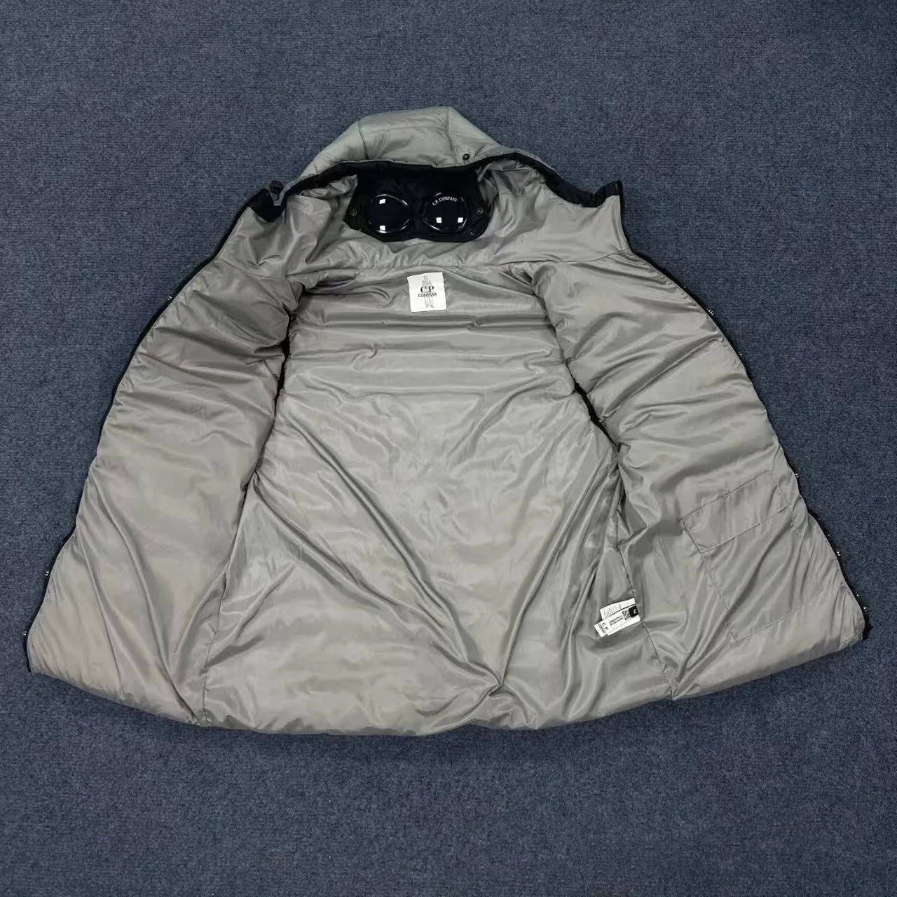Men's loose hooded cotton vest jacket in black, side view, showing hood and zip closure