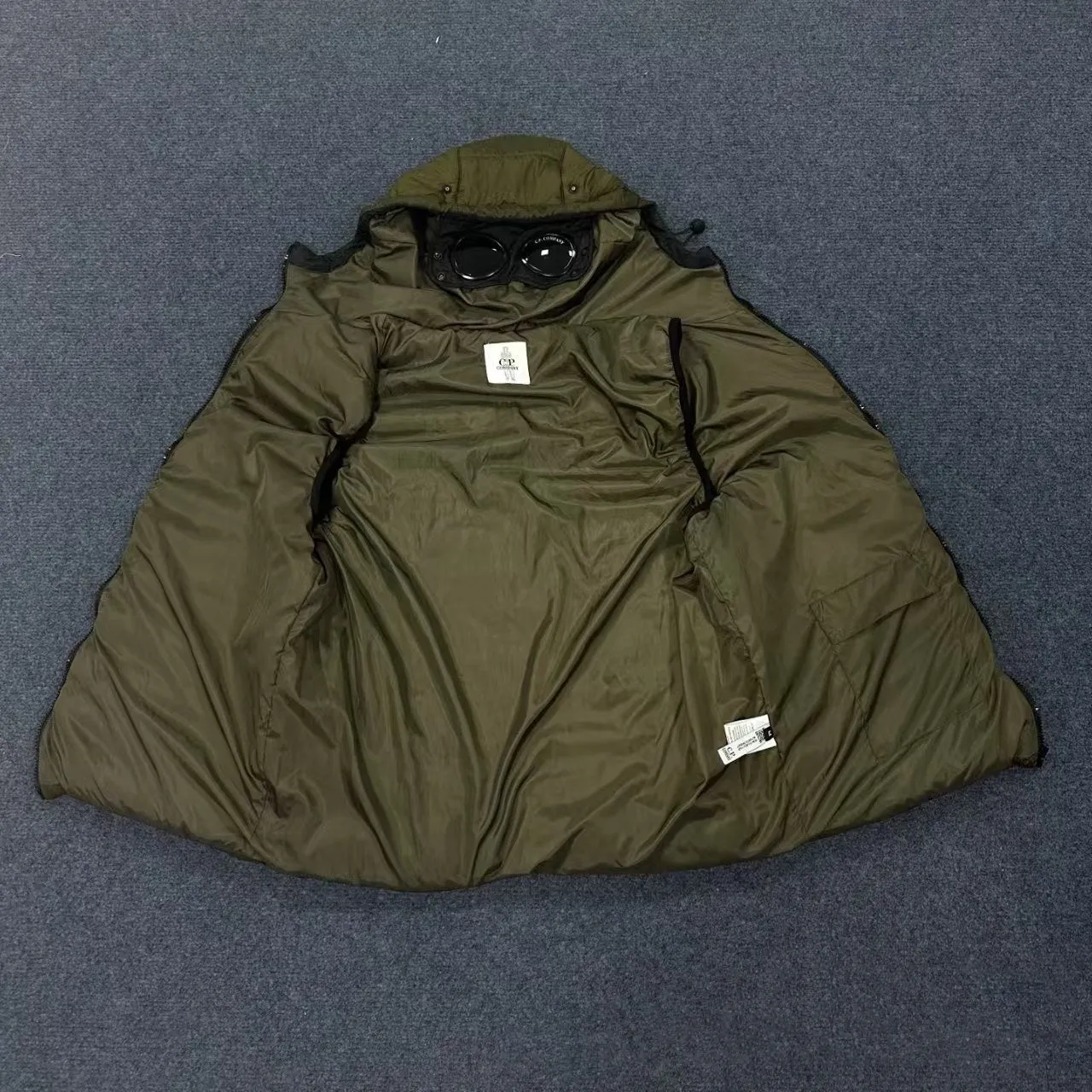 Men's loose hooded cotton vest jacket in black, side view, showing hood and zip closure