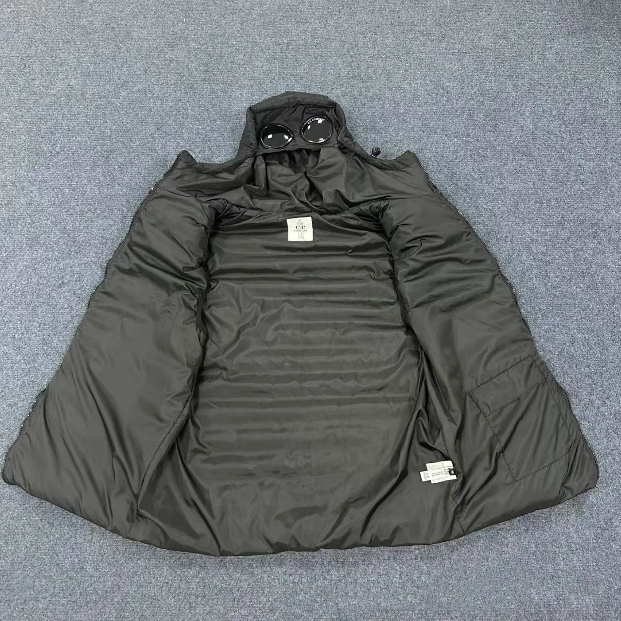 Men's loose hooded cotton vest jacket in black, side view, showing hood and zip closure