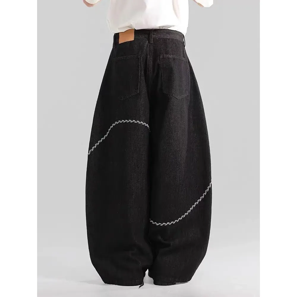 Black straight-leg denim trousers laid flat, showing zip fly and mid-waist design.
