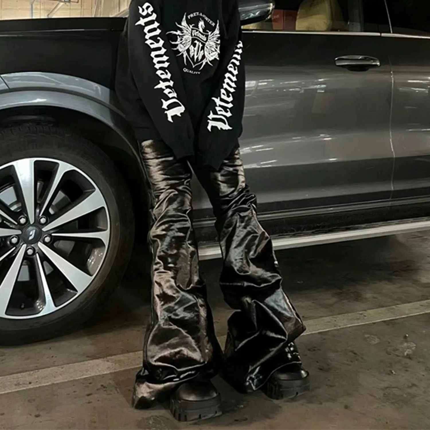 Black women's skinny jeans with a shiny patent leather coating on the denim fabric, shown in a straight-leg cut.