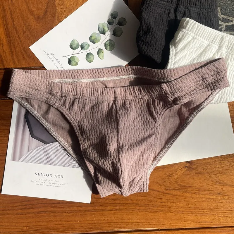 Men's solid colour pure cotton triangle underwear briefs on a mid waist, shown in apricot and black colour options.