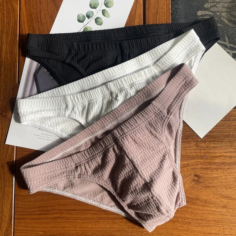 Men's solid colour pure cotton triangle underwear briefs on a mid waist, shown in apricot and black colour options.