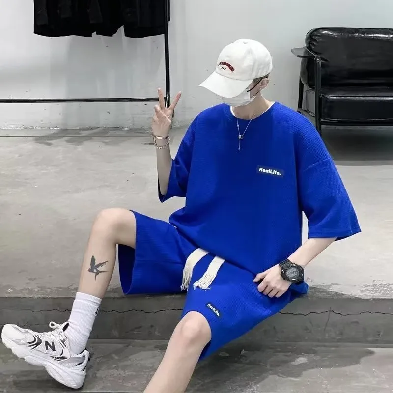 A waffle-textured leisure sports suit consisting of a short-sleeve top and shorts in a neutral colour.