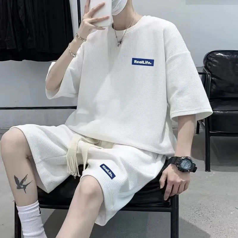 A waffle-textured leisure sports suit consisting of a short-sleeve top and shorts in a neutral colour.