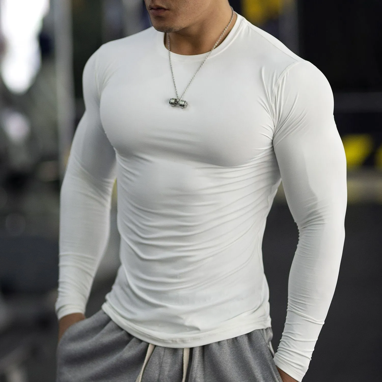Man wearing black slim fit long sleeve fitness tights for running or gym workout.