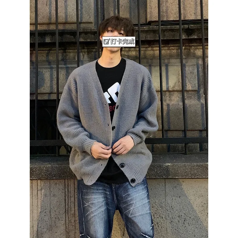 Men's solid colour V-neck knitted cardigan sweater in a loose fit on a hanger.