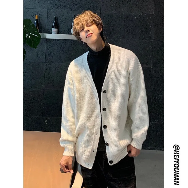 Men's solid colour V-neck knitted cardigan sweater in a loose fit on a hanger.