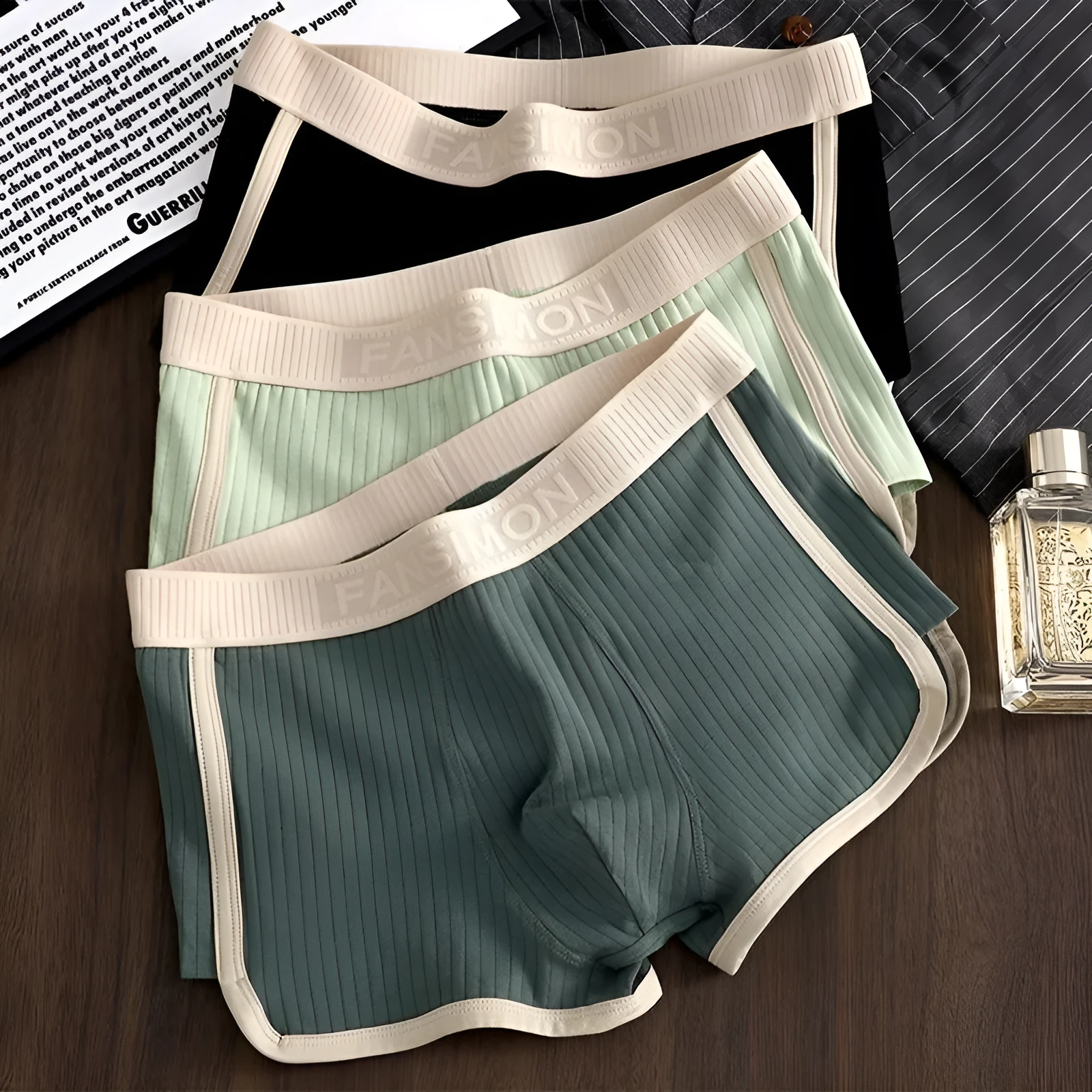 Three-pack of men's milk silk polyester boxer shorts in solid colours on a white background