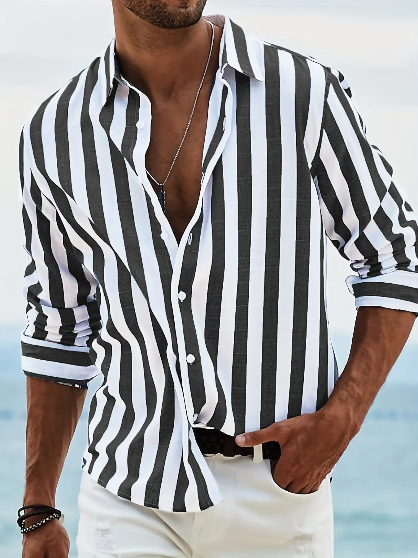 Man wearing a loose grey striped casual long-sleeved shirt with a cardigan style.