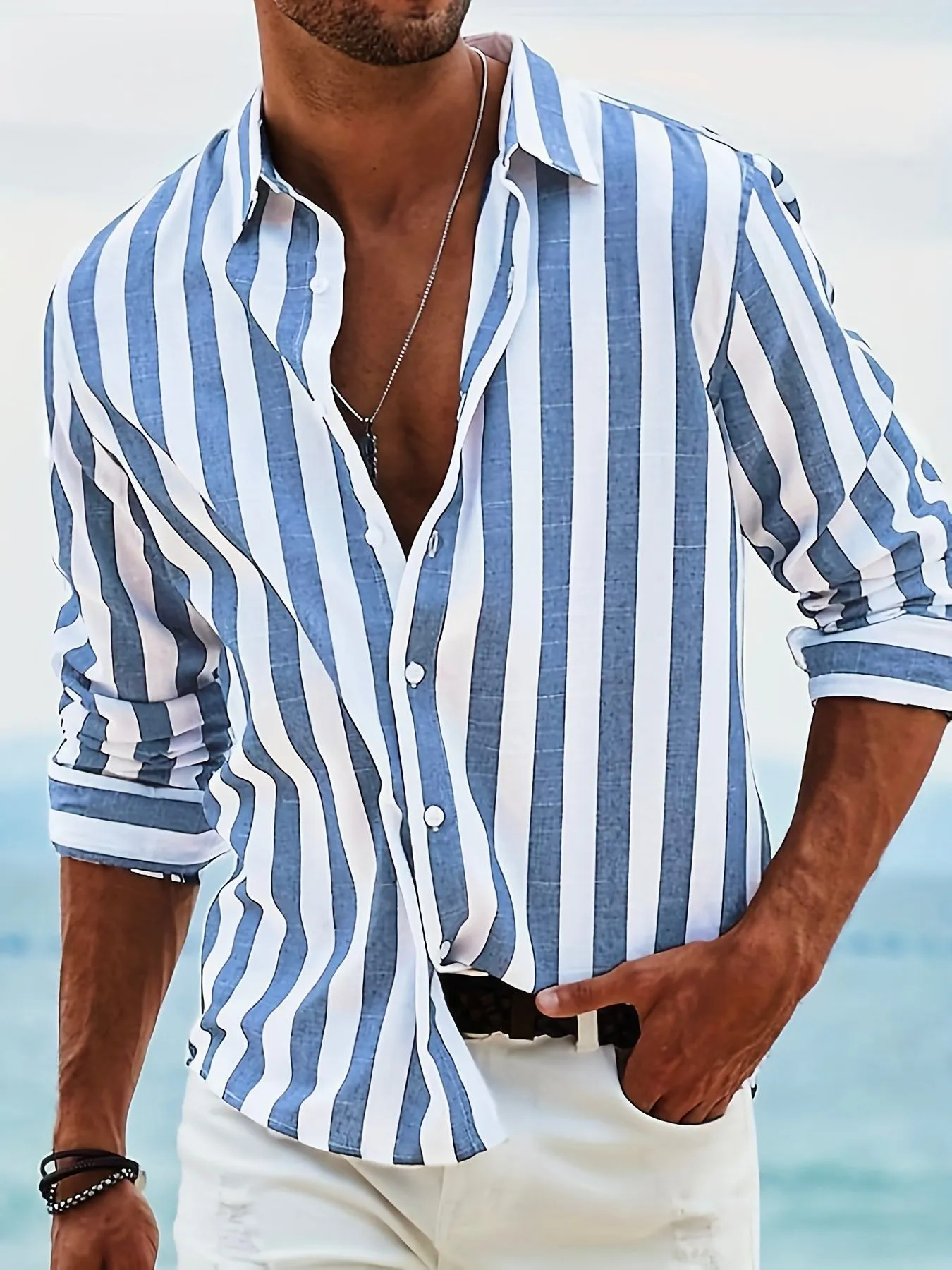Man wearing a loose grey striped casual long-sleeved shirt with a cardigan style.