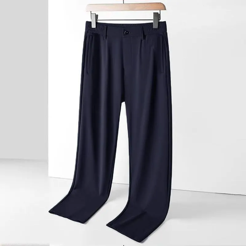 Man wearing black ice silk straight-leg loose casual trousers with an elastic waist.