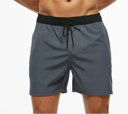 Men's blue stitching waist training shorts with zipper pockets and a drawstring, laid flat.