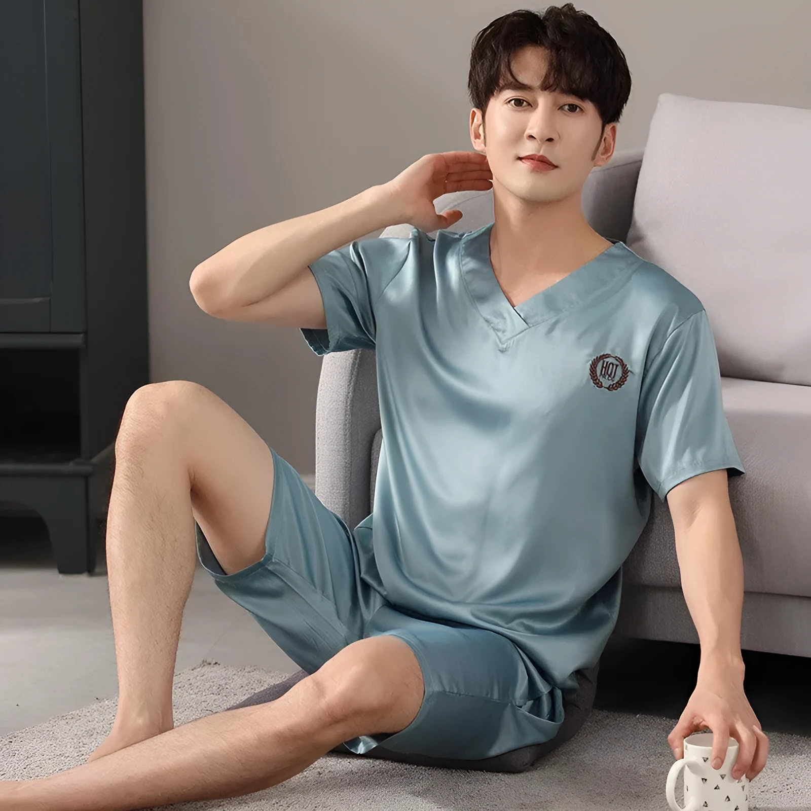 Man's loose-fitting ice silk pyjama set with short-sleeved shirt and shorts in a solid colour.