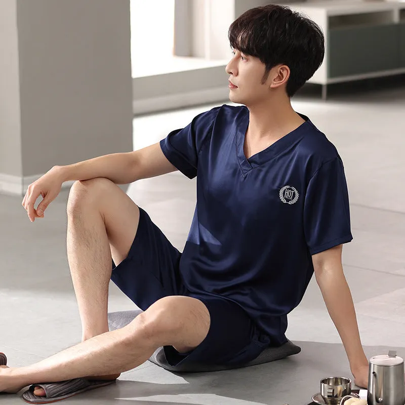 Man's loose-fitting ice silk pyjama set with short-sleeved shirt and shorts in a solid colour.