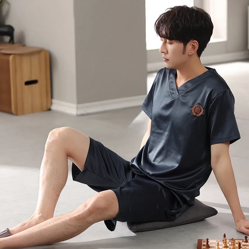 Man's loose-fitting ice silk pyjama set with short-sleeved shirt and shorts in a solid colour.
