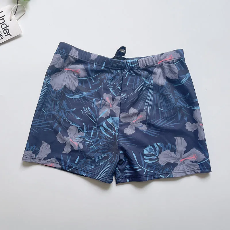 Men's loose-fit polyester swim trunks in dark blue with large flower print, three sizes available