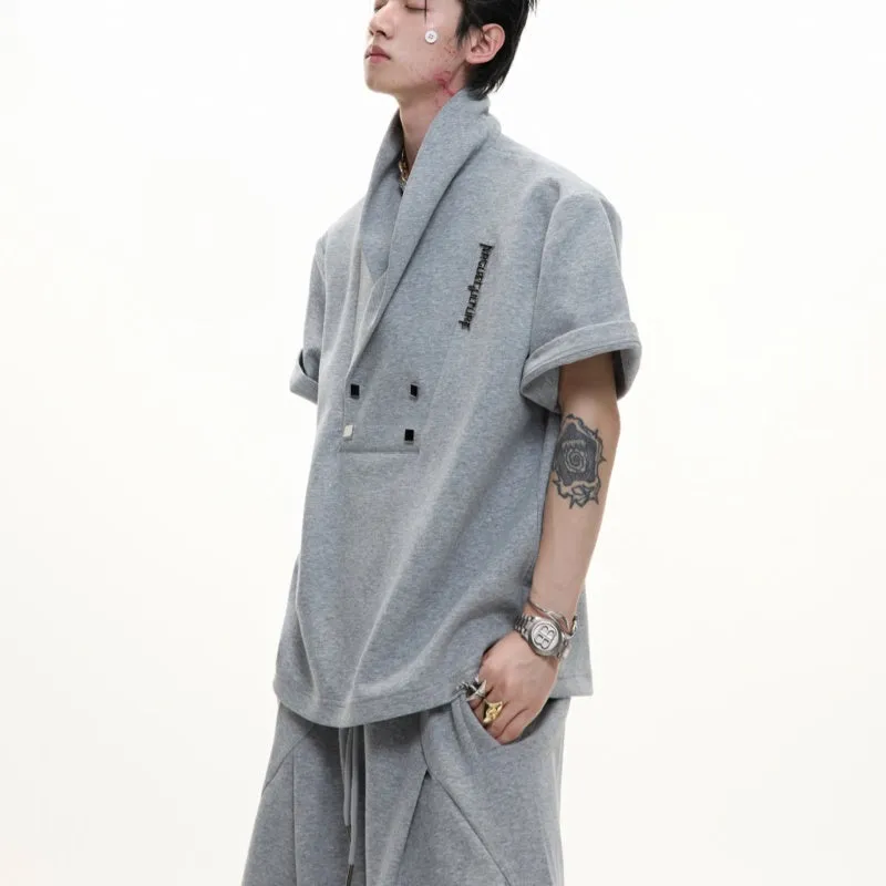 Men's dark grey V-neck short sleeve cotton sports jacket with padded shoulders and metal details, paired with matching shorts.