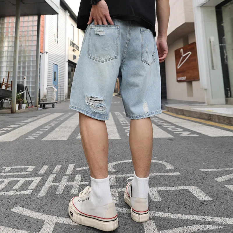 Men's light blue ripped denim shorts with a loose, straight leg fit on a plain background.