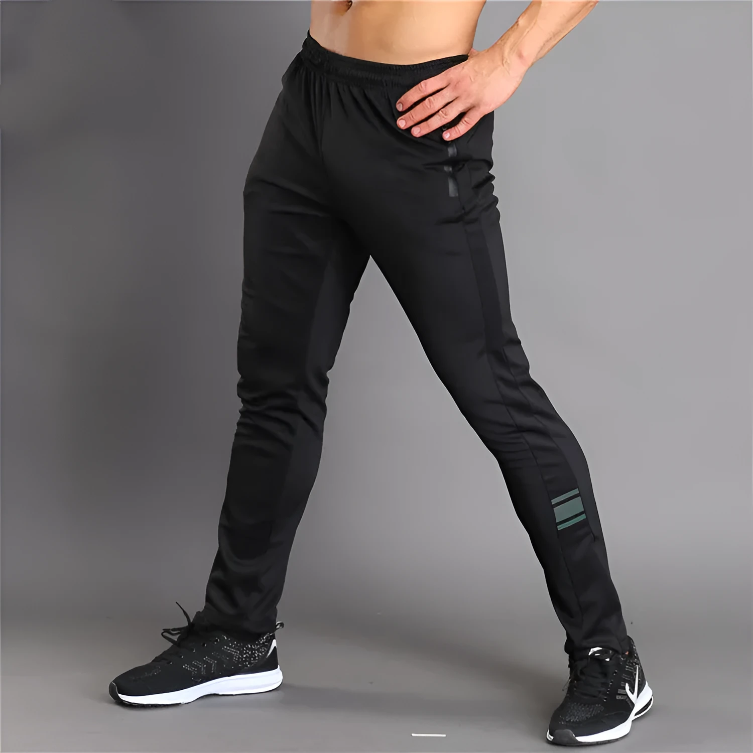 Black running fitness trousers with colour-changing reflective print, slim fit, zippered pockets, polyester fabric