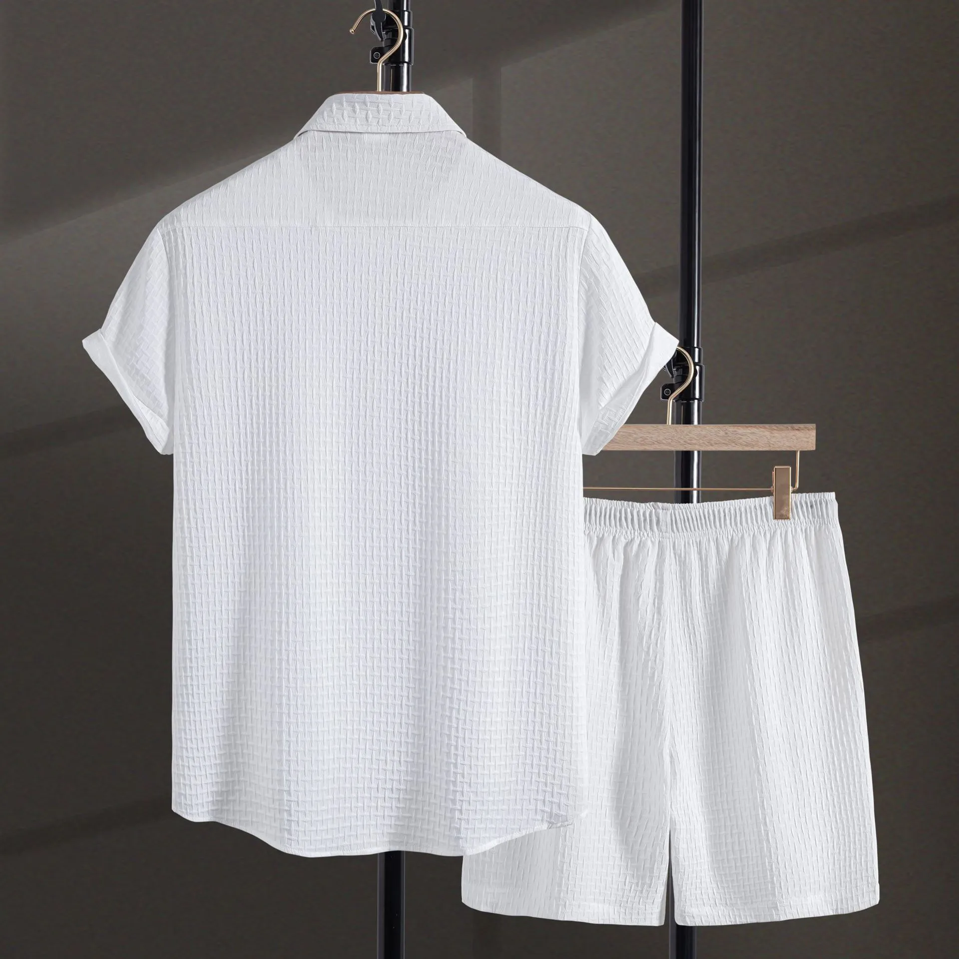 Men's black cotton blend short sleeve shirt and shorts beach suit laid flat.