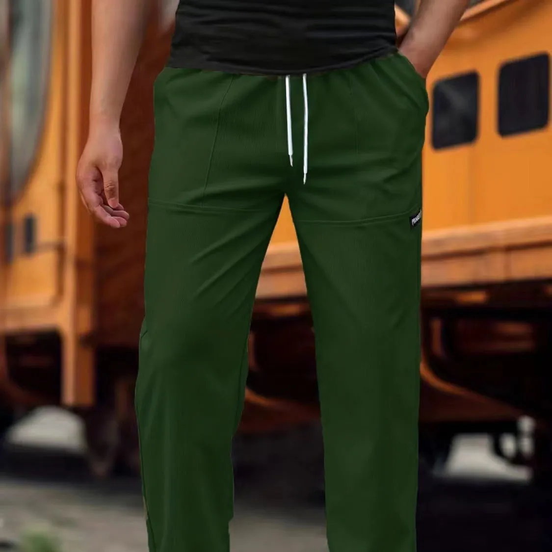 Men's light grey polyester trousers for spring and autumn wear, laid flat.
