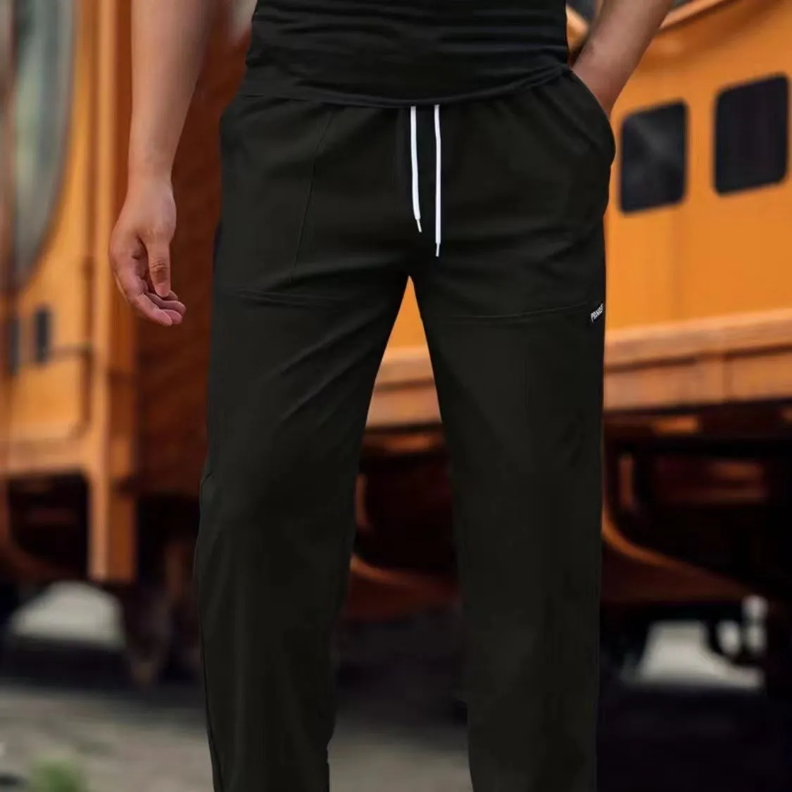 Men's light grey polyester trousers for spring and autumn wear, laid flat.